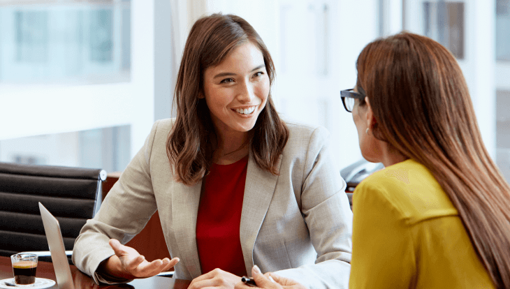 RevOps interview questions, image of two women sitting across from each other talking at desk