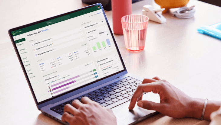 sales compensation dashboard image of person working on laptop with quotapath sales compensation dashboard visible