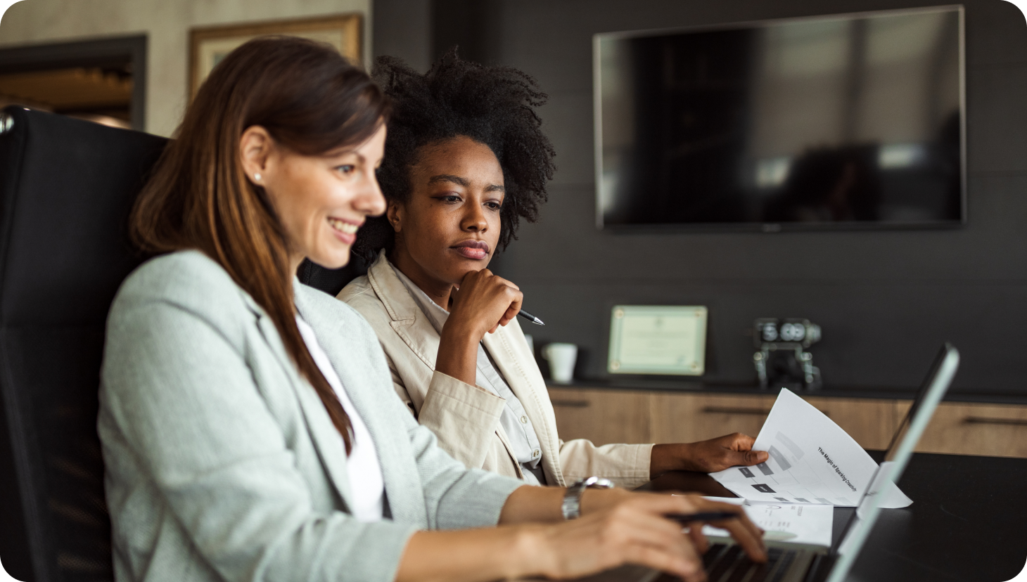 women working at desk intently