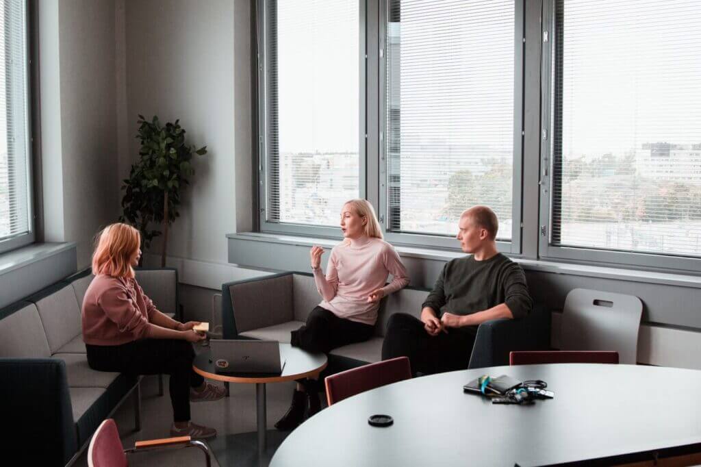 People sitting in an office lounge area discussing work