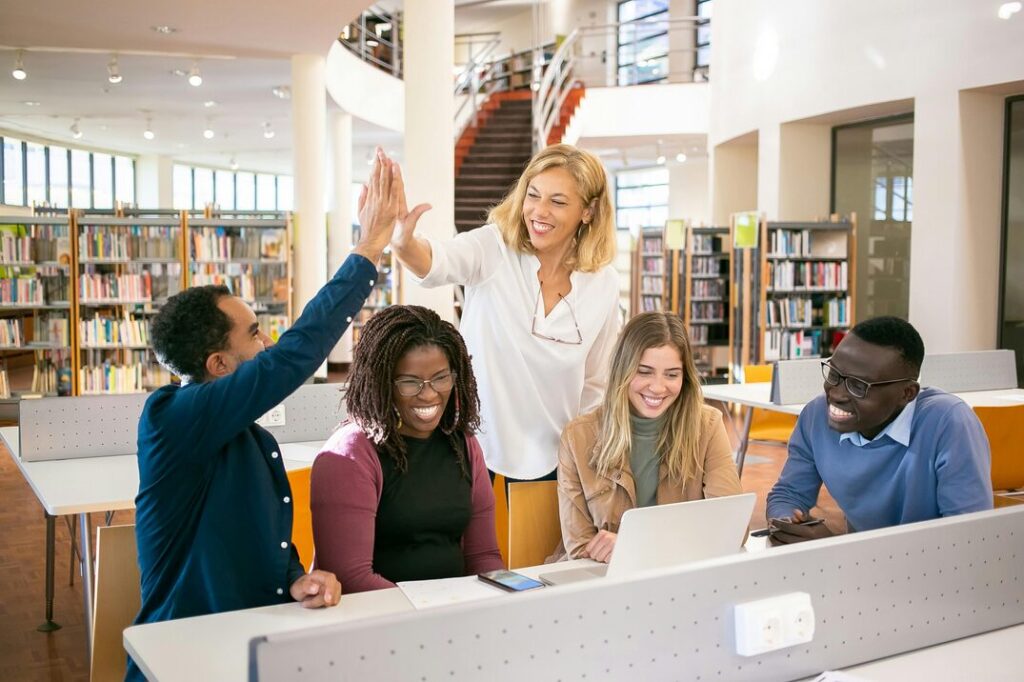 coworkers high fiving in a library