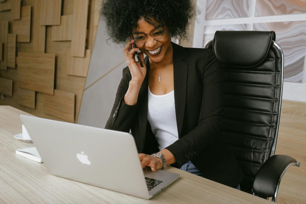 Woman on lap top at work and talking on phone